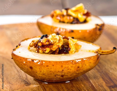 Two caramelized pears, filled with nuts and dried fruit, on a wooden board