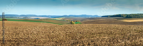 wide plowed fields spread out among the hills, forests and mountains on the h...