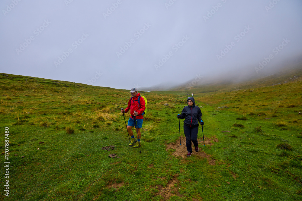 Obraz premium tourists on a mountain trail on a cloudy autumn day