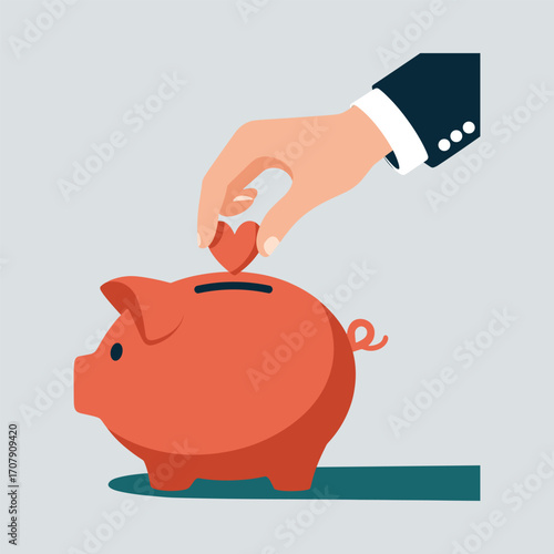 Hand placing heart into a red piggy bank for donations Keywords: donate, donation, giving, charity