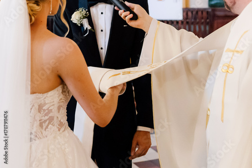Φωτογραφία Close-up of priest’s stole placed over couple’s hands during wedding vow exchang