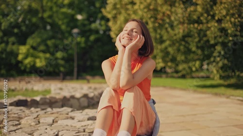 Meditation and peace: pretty girl meditating with face to sun in park