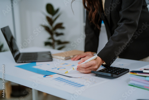 Happy young asian businesswoman sitting on her workplace in the office. Young woman working at laptop in the office.