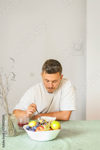 Casual Morning Routine: Adult Male Eating Muesli in Modern Dinning Room.