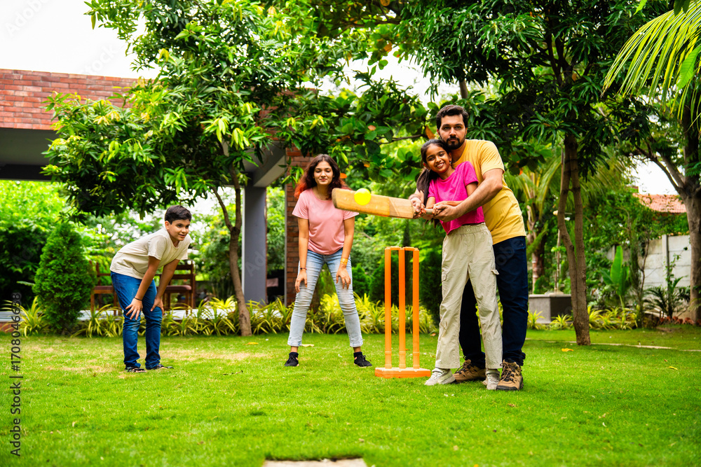 Fototapeta premium Indian Asian family bonding through outdoor cricket batting in garden, enjoying fun and play