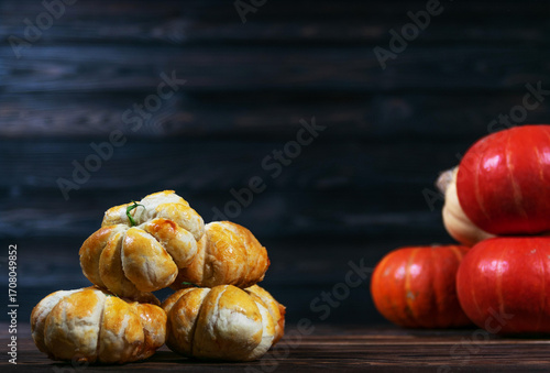 Pumpkin shaped buns stacked on rustic wooden table