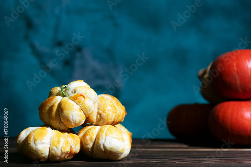 Pumpkin-shaped pastries on wooden surface