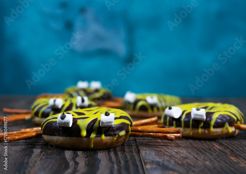 Spider shaped chocolate donuts on wooden table