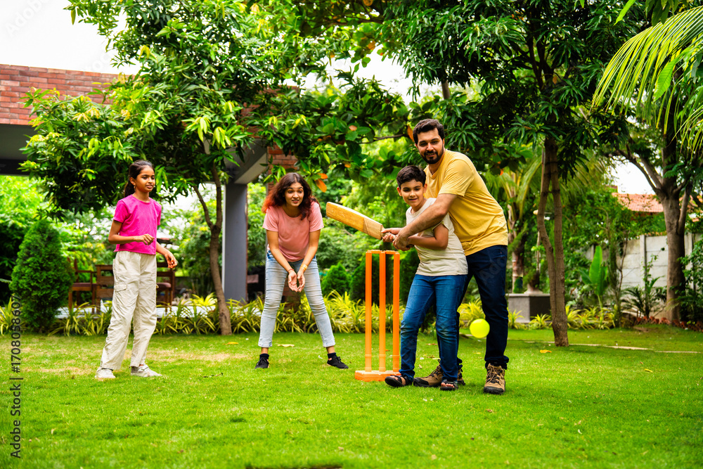 Obraz premium Indian family playing cricket batting joyfully in garden during outdoor bonding time