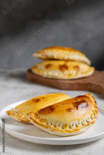 Stuffed empanadas on a plate on the table. Argentine empanadas.