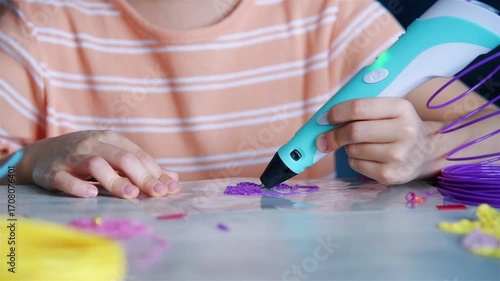Сhildren's hands drawing with 3D pen on table. Creativity and innovation in art concept. Close up