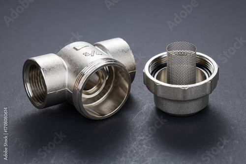 Coarse water filter for plumbing works isolated on dark background