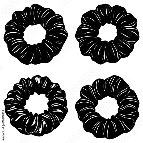 Four black scrunchies with white highlights arranged on a white background in a square formation
