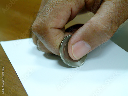 Close-up of a man's hand rubbing paper with a coin to get a surprise.