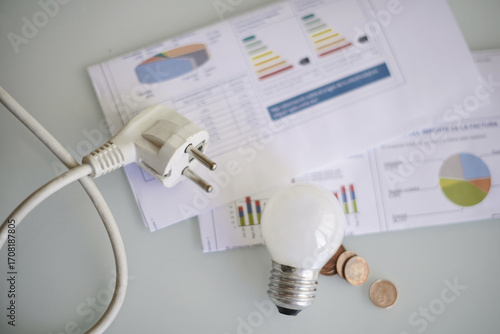 Electricity bill with a plug and light bulb, household economics and energy or electricity prices