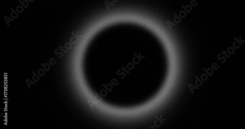 Abstract blurred grainy hole with pulsing halo, looped on black background