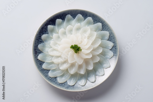 Thinly sliced fugu sashimi served in traditional floral pattern
