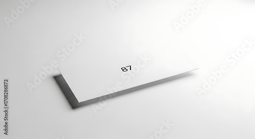 White Paper Card Displaying Number 87 on a Minimalist Background