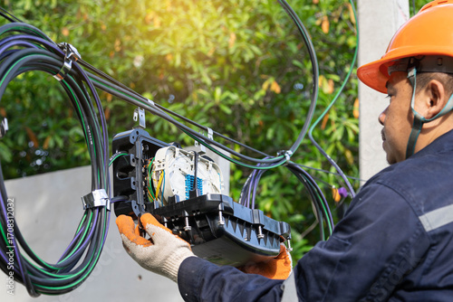 Tablou pe pânză Engineer or technician checking fiber optic cables in internet splitter box
