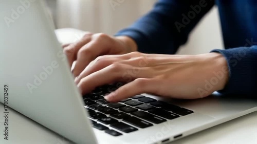 Close-up of hands typing on a modern laptop keyboard for productive work