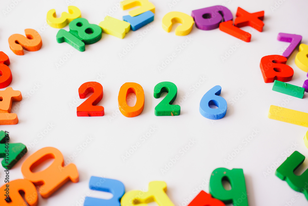 Naklejka premium Cheerful colorful wooden blocks forming 2026 on white background, New Year celebration concept