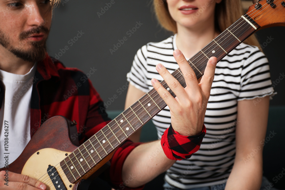 Obraz premium Tutor teaching woman to play guitar at home, closeup