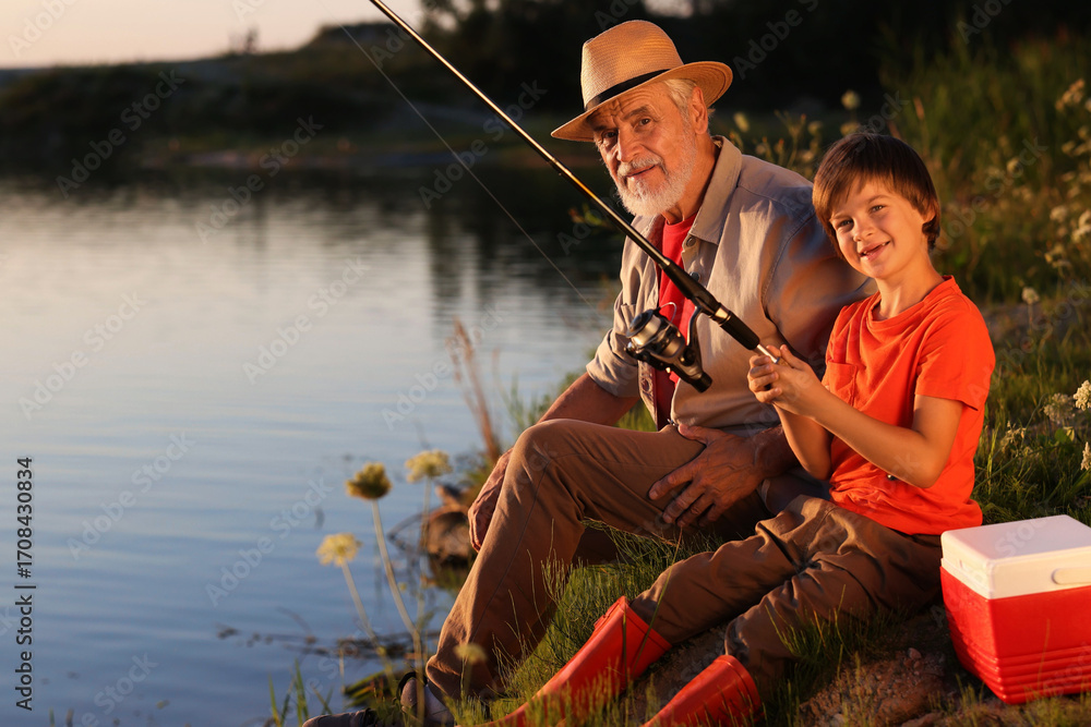 Εκτύπωση καμβά Grandfather and his nephew fishing together near river outdoors