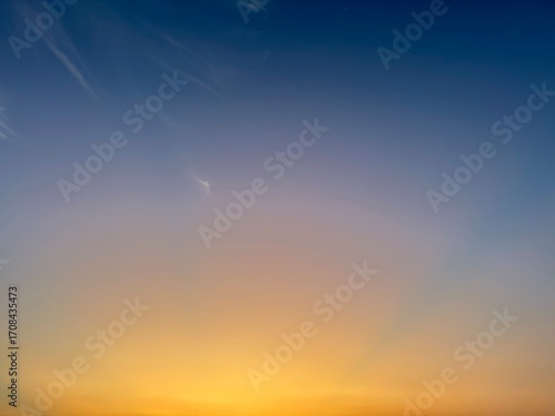 Vibrant sunset gradient paints the sky with warm golden hues and soft wispy clouds, evoking peace and wonder.