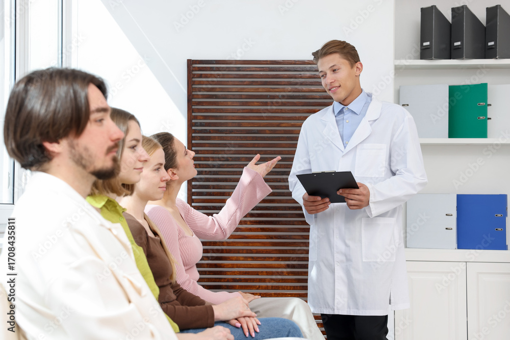 Fototapeta premium People waiting in queue on chairs at hospital