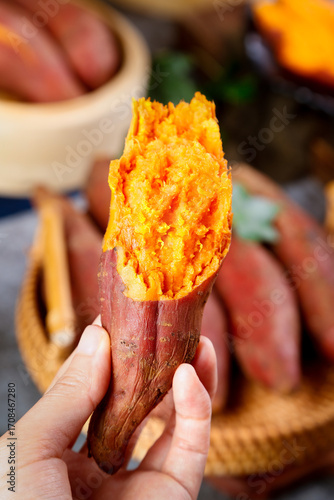 Fresh Roasted Sweet Potato with Orange Flesh Held in Hand - Natural Healthy Food Detail