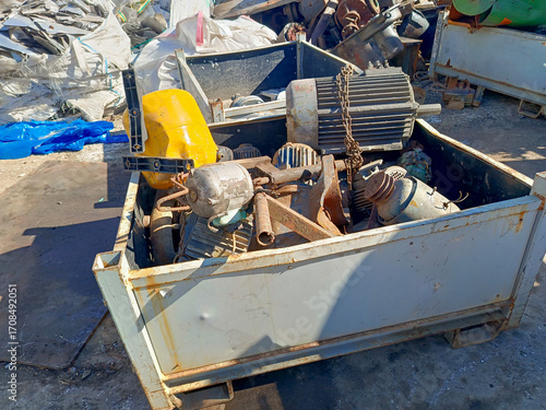 фотографія A large metal container filled with scrap aluminum, motors, and other industrial waste at a recycling facility, a concept of industrial recycling, waste management, and resource recovery