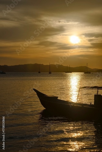 sunset in the evening with silhouette of boat