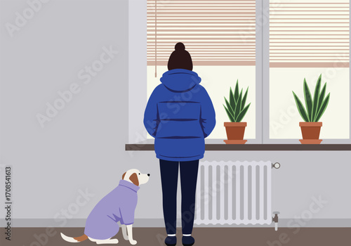 A woman in a blue puffer jacket stands next to a dog wearing a purple sweater in a room with a radiator and a window with plants, creating a cozy and warm indoor scene, showcasing winter attire