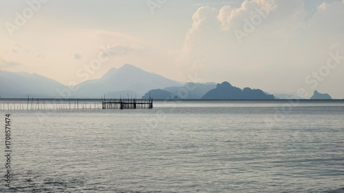 A scenic view of a body of water with mountains in the background and a small wooden pier