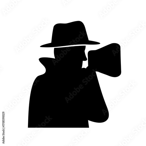 Silhouette of a man with fedora hat holding old style movie camera