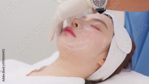 A close-up of a young Asian woman receiving a Botox or dermal filler injection in her face from a professional. Concept for beauty clinics, dermatology, and anti-aging treatments.
