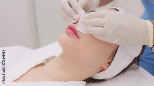 A close-up of a young Asian woman receiving a Botox or dermal filler injection in her face from a professional. Concept for beauty clinics, dermatology, and anti-aging treatments.