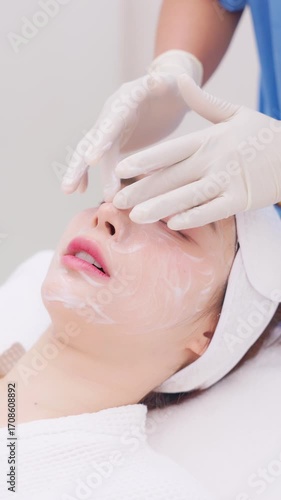 A close-up of a young Asian woman receiving a Botox or dermal filler injection in her face from a professional. Concept for beauty clinics, dermatology, and anti-aging treatments.