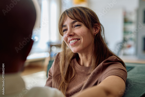 Fotografie Happy woman smiling and engaging in conversation with a man while relaxing toget