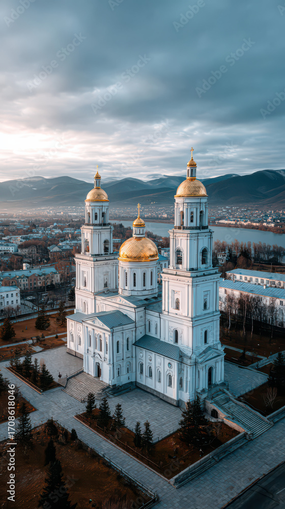 Obraz premium Golden Domes: A breathtaking aerial shot of a grand building with shimmering gold domes and elegant architecture, nestled amidst a serene cityscape under a picturesque cloudy sky.