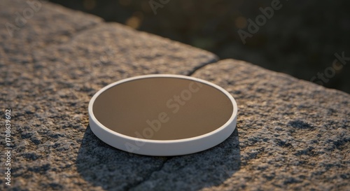 Round, light-gray coaster on gray stone