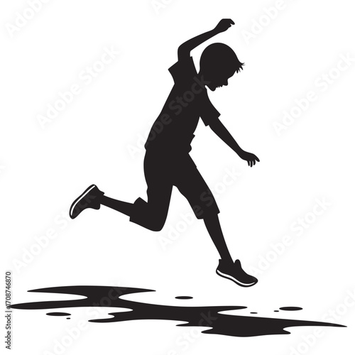 Boy jumping puddle