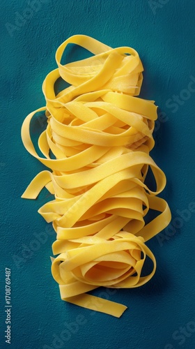 Fresh Yellow Fettuccine Pasta Arranged in Rose Shapes on a Blue Background.