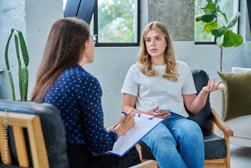 Young woman patient talking with female psychologist, mental counselor