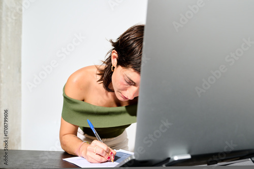 writing notes on a resume while her work day