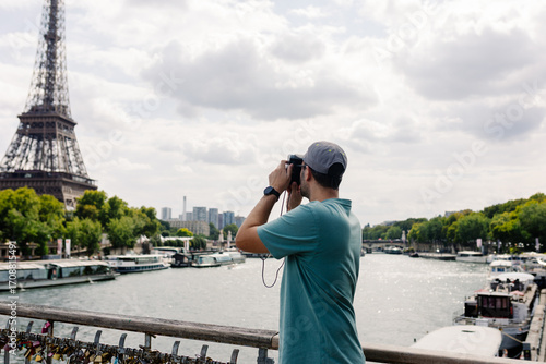 Tourist capturing photos of the Eiffel Tower on a sunny day