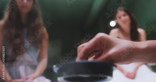 Hand placing teapot lid during tea gathering, close-up