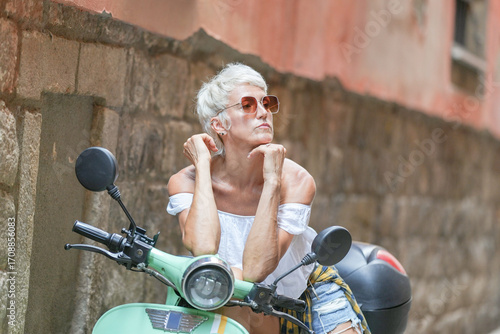 Photography A woman is sitting on a green scooter
