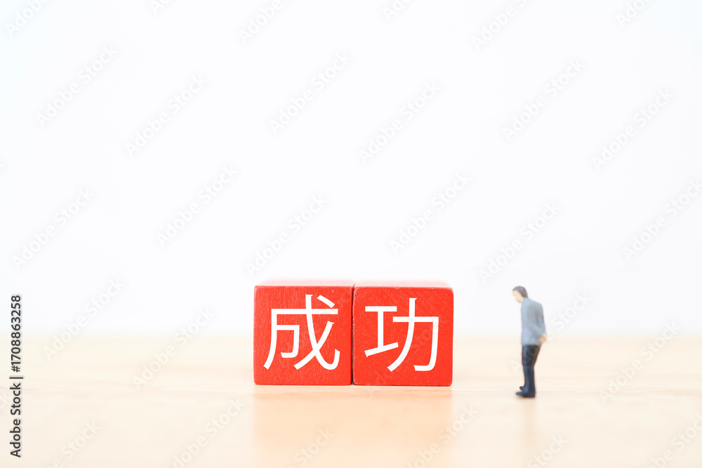 Naklejka premium 成功を見つめるミニチュアビジネスマンと赤いブロック