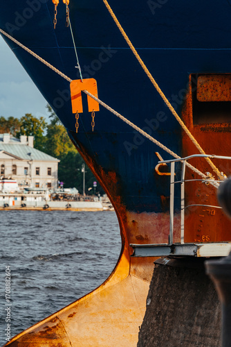 Large ship docked at port with visible hull and mooring lines